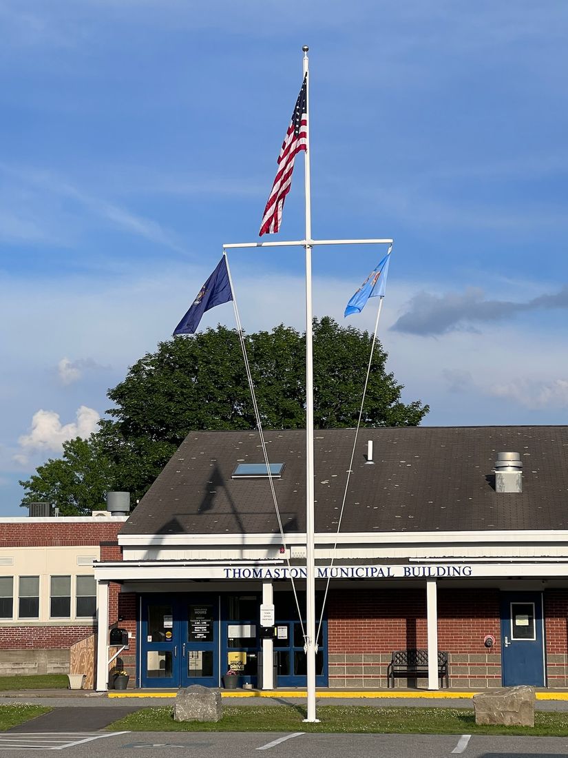 Commercial nautical yardarm flagpole at a Maine municipal building