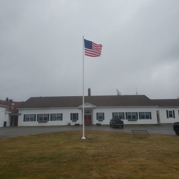 Tall commercial flagpole flying the American flag
